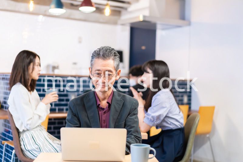 カフェで仕事をする中年男性