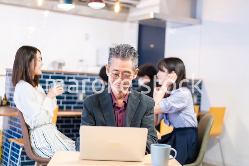 カフェで仕事をする中年男性