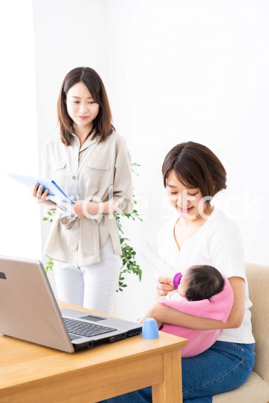 赤ちゃんを連れてオフィスで働く女性