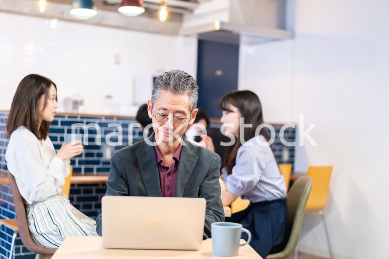 カフェで仕事をする中年男性