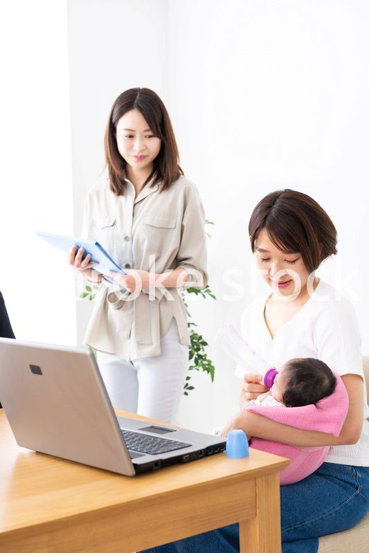 赤ちゃんを連れてオフィスで働く女性