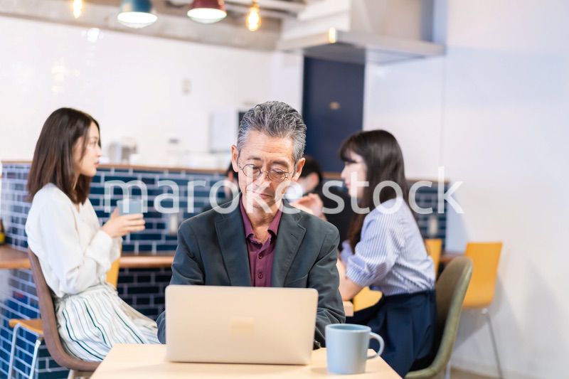 カフェで仕事をする中年男性