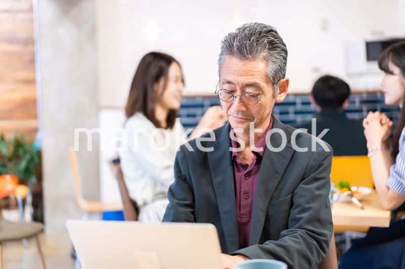 カフェで仕事をする中年男性