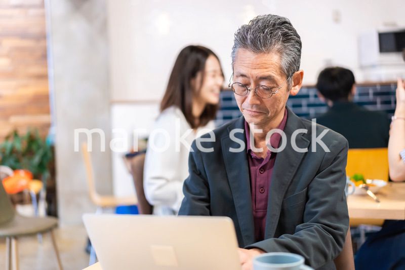 カフェで仕事をする中年男性