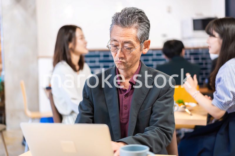 カフェで仕事をする中年男性