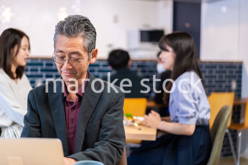 カフェで仕事をする中年男性