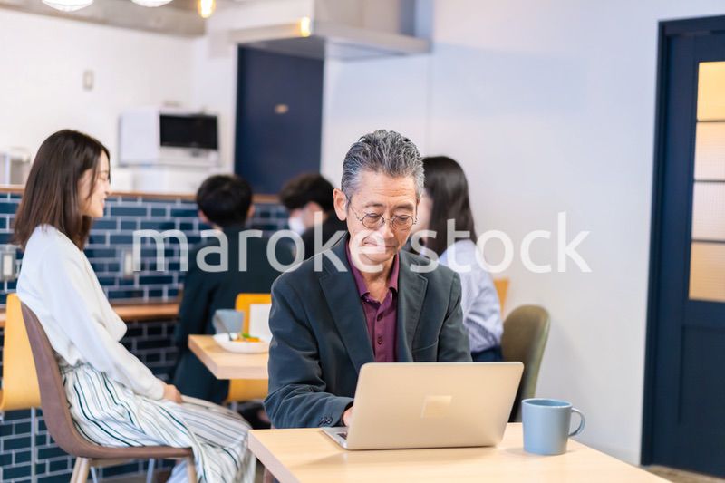 カフェで仕事をする中年男性