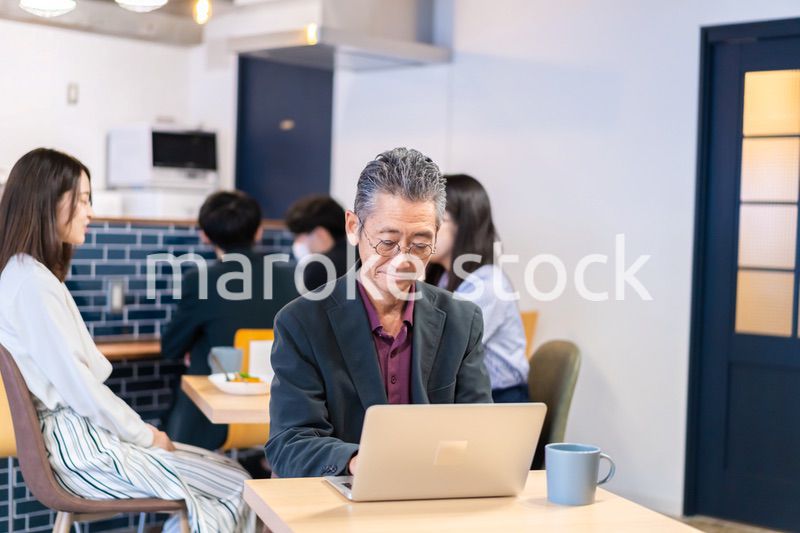 カフェで仕事をする中年男性