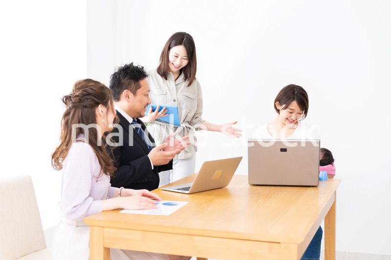 赤ちゃんを連れてオフィスで働く女性