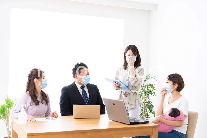 赤ちゃんを連れてオフィスで働く女性