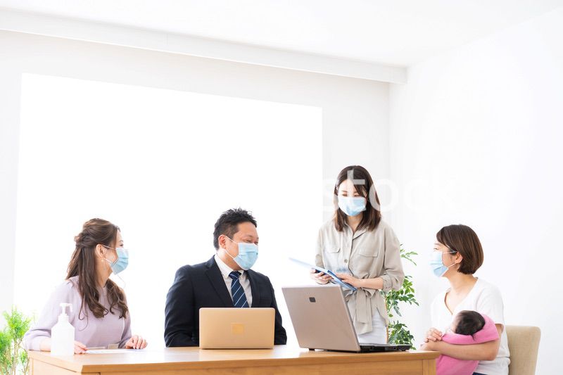 赤ちゃんを連れてオフィスで働く女性