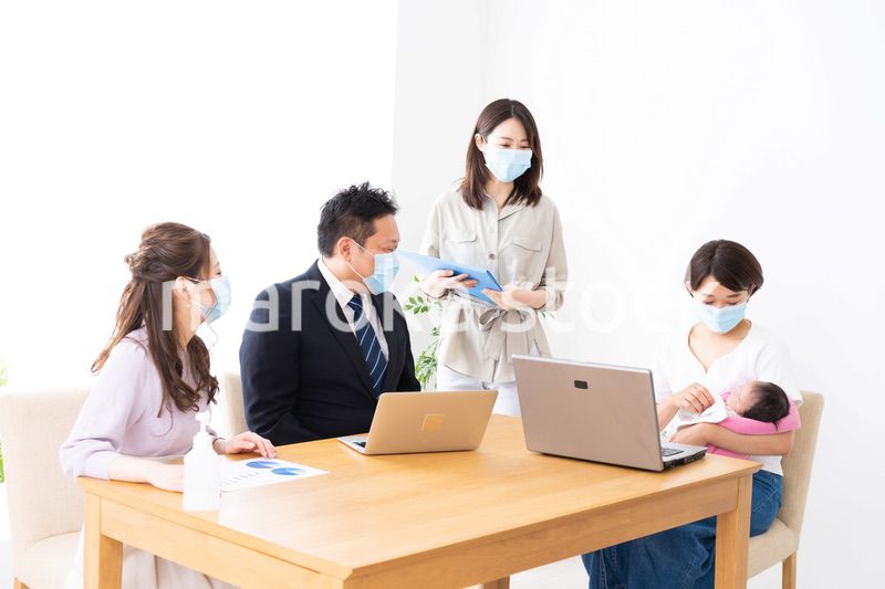 赤ちゃんを連れてオフィスで働く女性