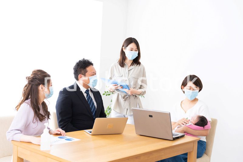 赤ちゃんを連れてオフィスで働く女性