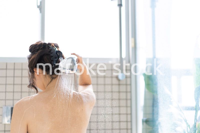 お風呂でシャワーを浴びる若い女性