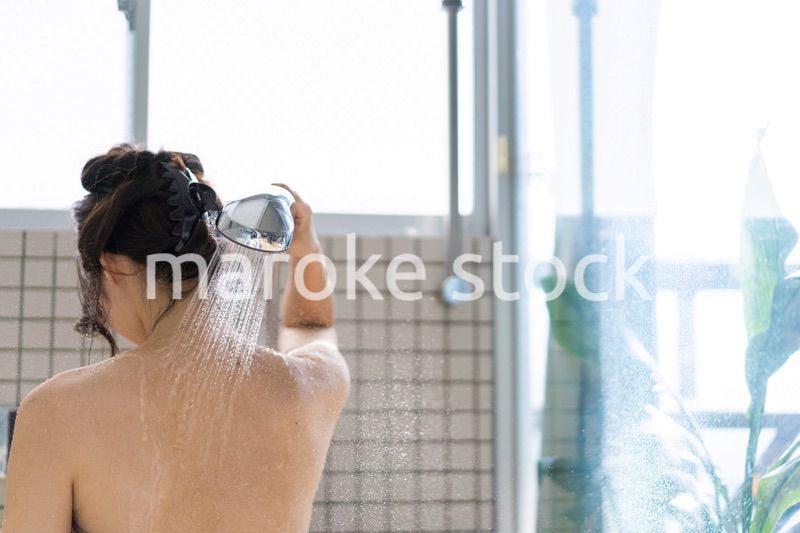 お風呂でシャワーを浴びる若い女性