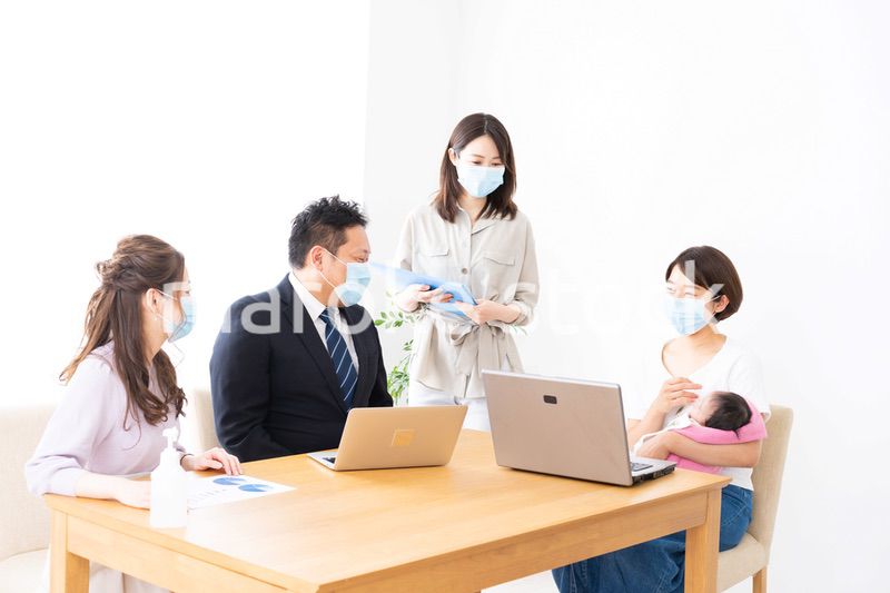 赤ちゃんを連れてオフィスで働く女性