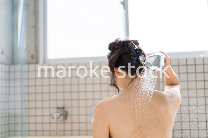 お風呂でシャワーを浴びる若い女性