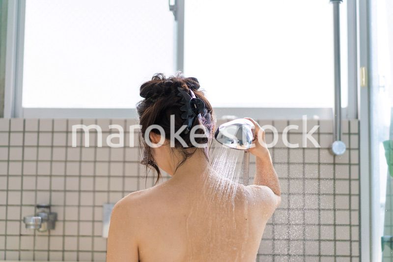 お風呂でシャワーを浴びる若い女性