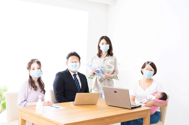 赤ちゃんを連れてオフィスで働く女性