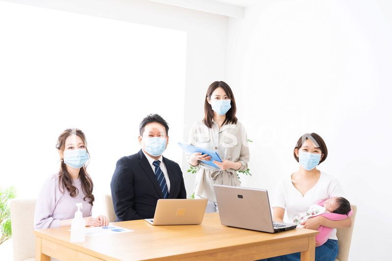 赤ちゃんを連れてオフィスで働く女性