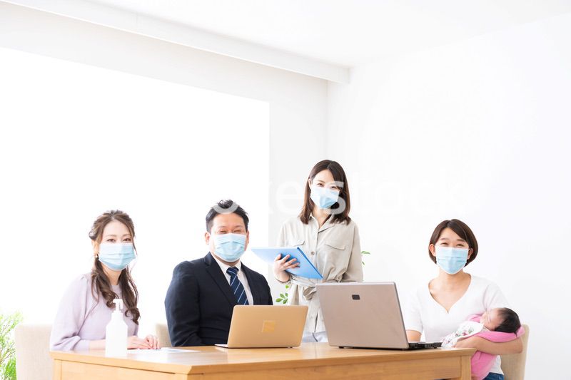 赤ちゃんを連れてオフィスで働く女性