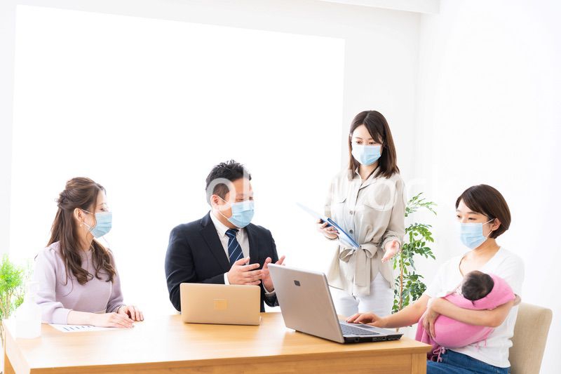 赤ちゃんを連れてオフィスで働く女性