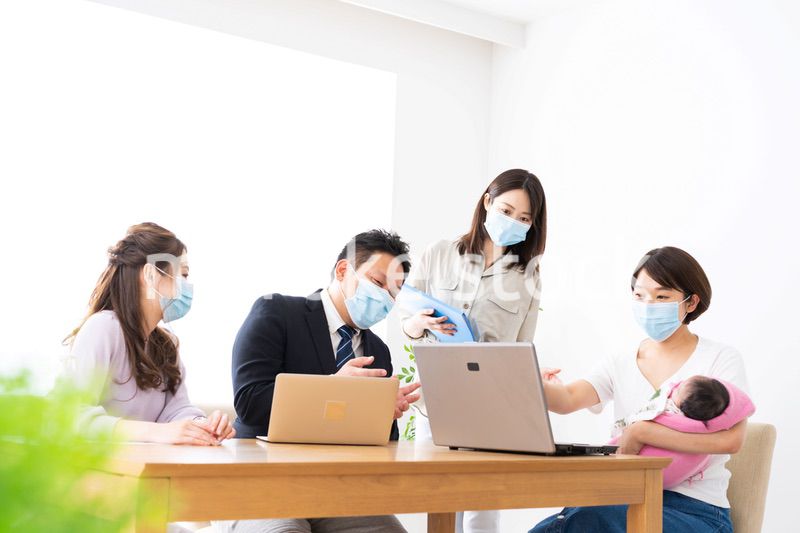 赤ちゃんを連れてオフィスで働く女性