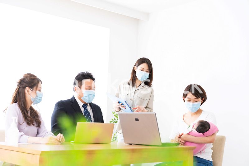 赤ちゃんを連れてオフィスで働く女性