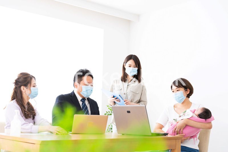 赤ちゃんを連れてオフィスで働く女性