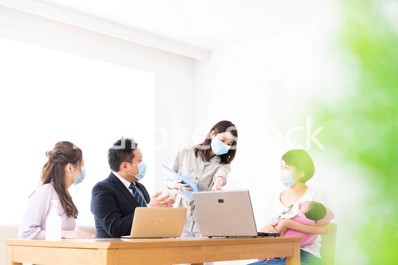 赤ちゃんを連れてオフィスで働く女性