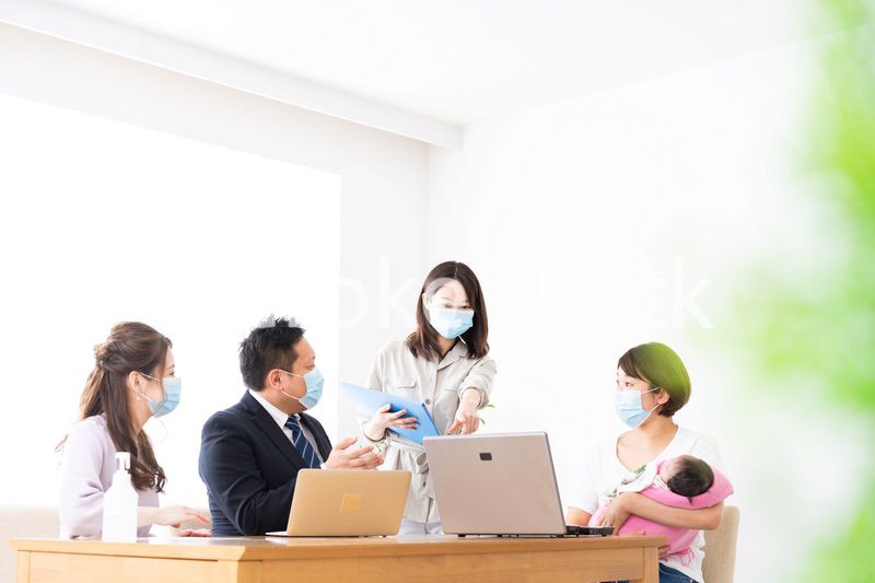 赤ちゃんを連れてオフィスで働く女性