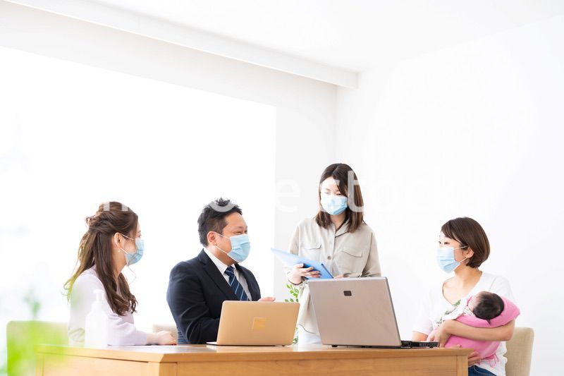 赤ちゃんを連れてオフィスで働く女性