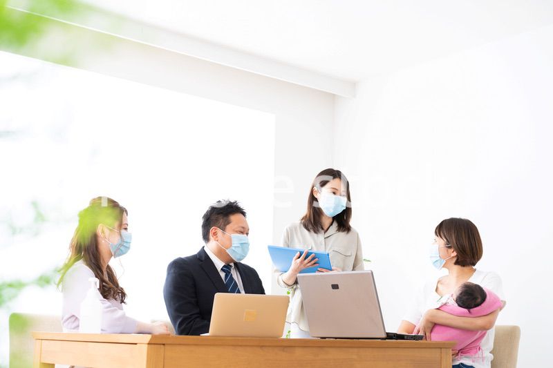 赤ちゃんを連れてオフィスで働く女性