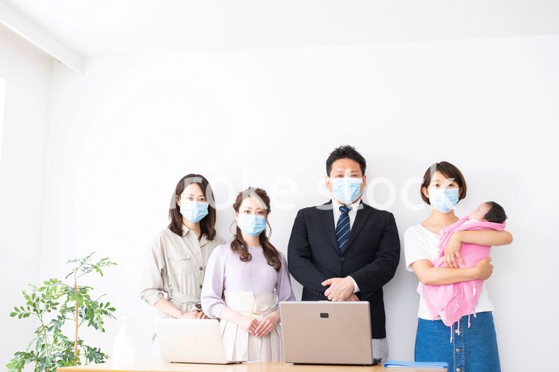 赤ちゃんを連れてオフィスで働く女性