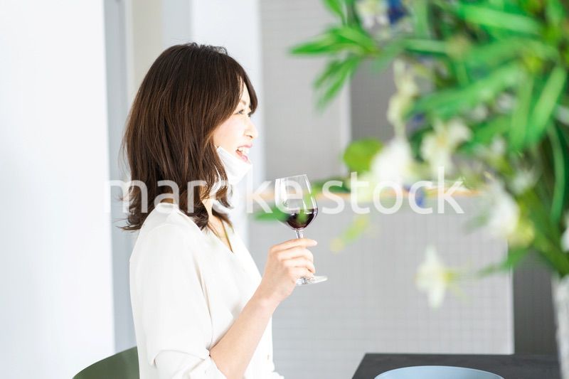 マスクをしてお酒を飲む若い女性
