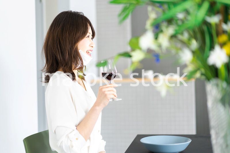 マスクをしてお酒を飲む若い女性