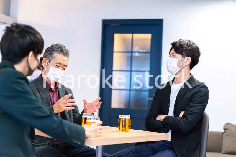 マスクをしてレストランで会話をする人々