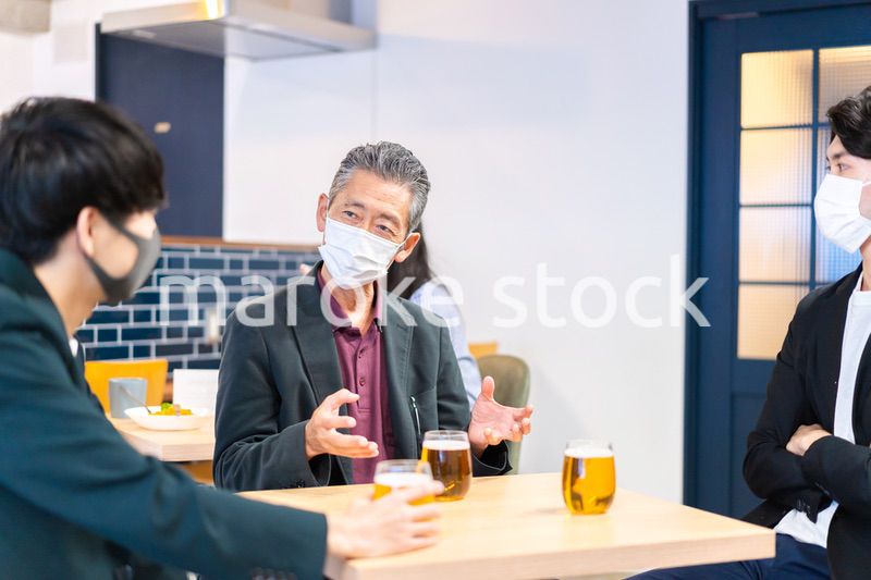 マスクをしてレストランで会話をする人々