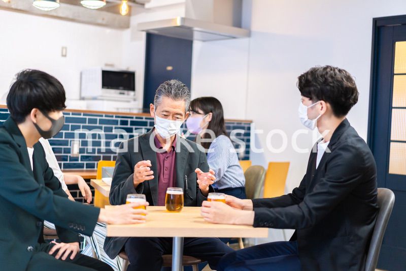 マスクをしてレストランで会話をする人々