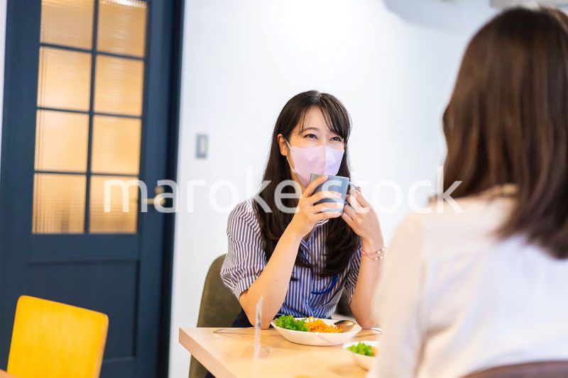 マスクをしてランチをする2人の若い女性