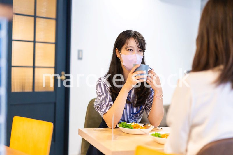 マスクをしてランチをする2人の若い女性