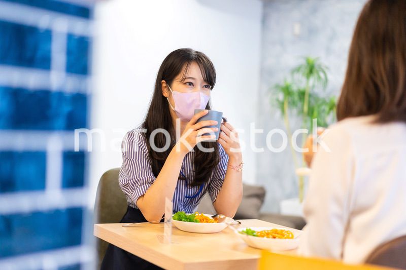 マスクをしてランチをする2人の若い女性