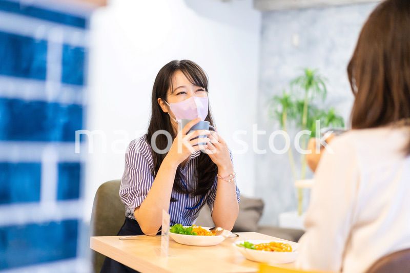 マスクをしてランチをする2人の若い女性
