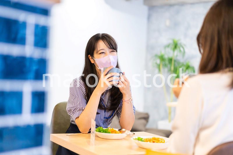 マスクをしてランチをする2人の若い女性