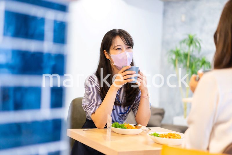 マスクをしてランチをする2人の若い女性