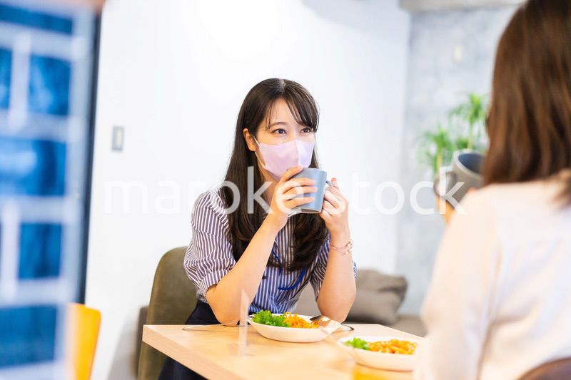 マスクをしてランチをする2人の若い女性