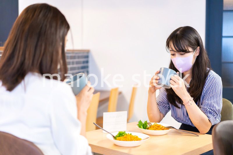 マスクをしてランチをする2人の若い女性