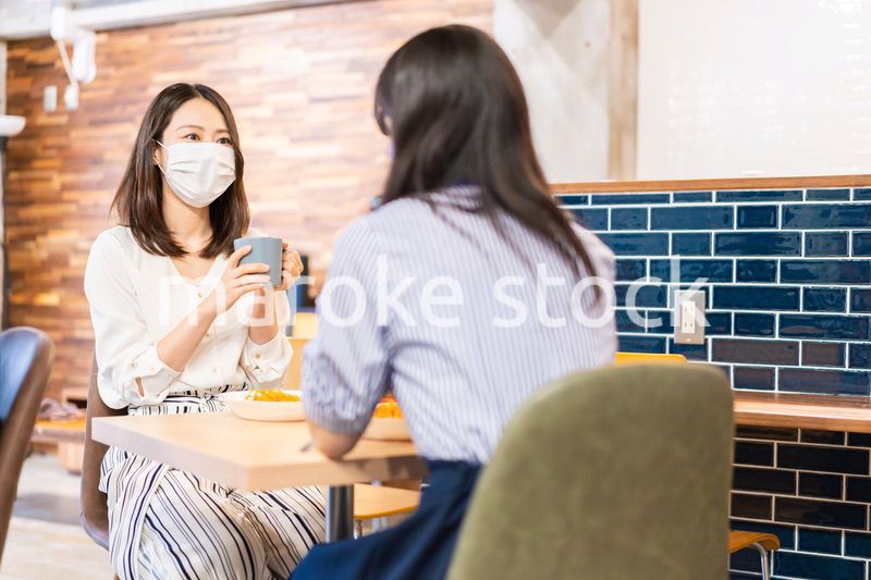 マスクをしてランチをする2人の若い女性
