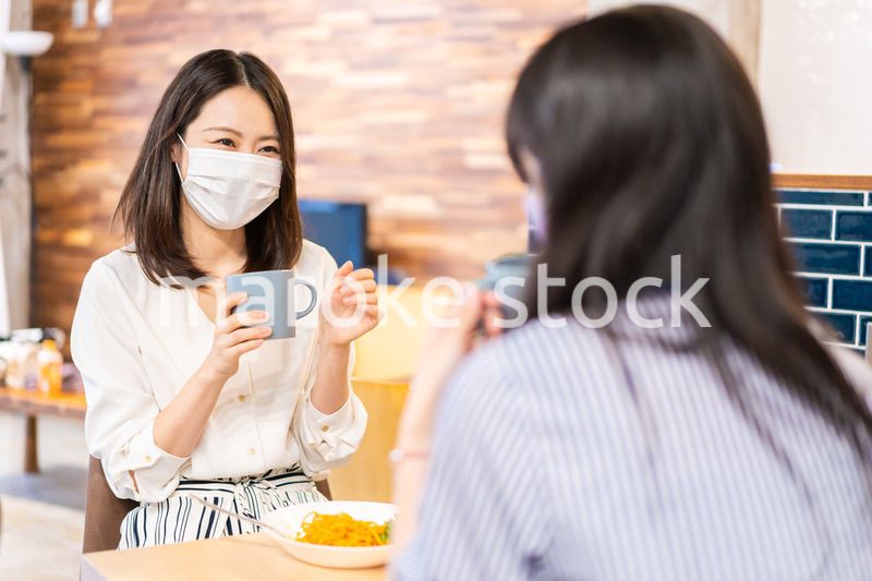 マスクをしてランチをする2人の若い女性