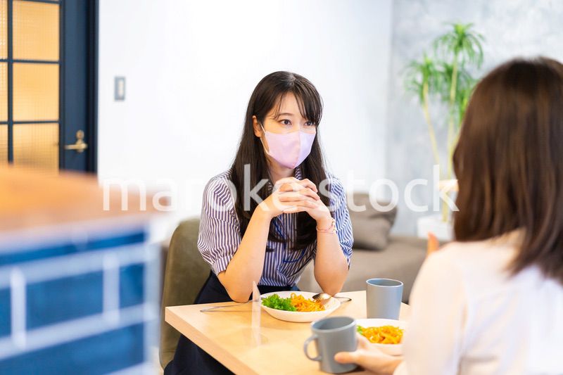 マスクをしてランチをする2人の若い女性
